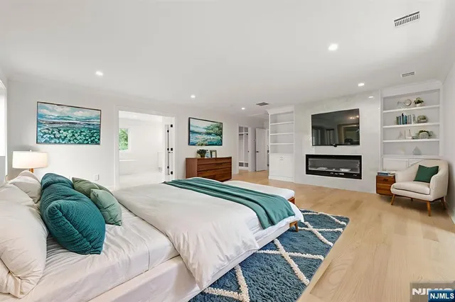 a spacious bedroom with a bed a couch and a flat screen tv