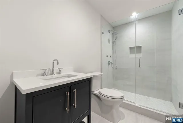 a view of an empty room with a cabinet and wooden floor