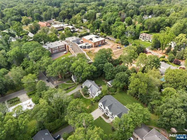 an aerial view of residential house with outdoor space and trees all around