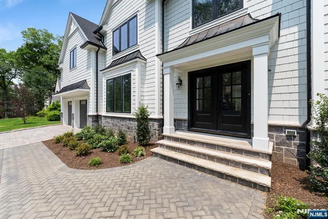 a view of a house with a large window and flower plants