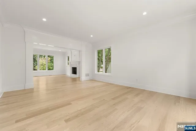 an empty room with windows and wooden floor