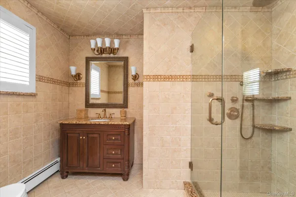 a bathroom with a granite countertop shower sink and mirror