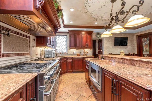 a kitchen with stainless steel appliances granite countertop a sink stove and cabinets