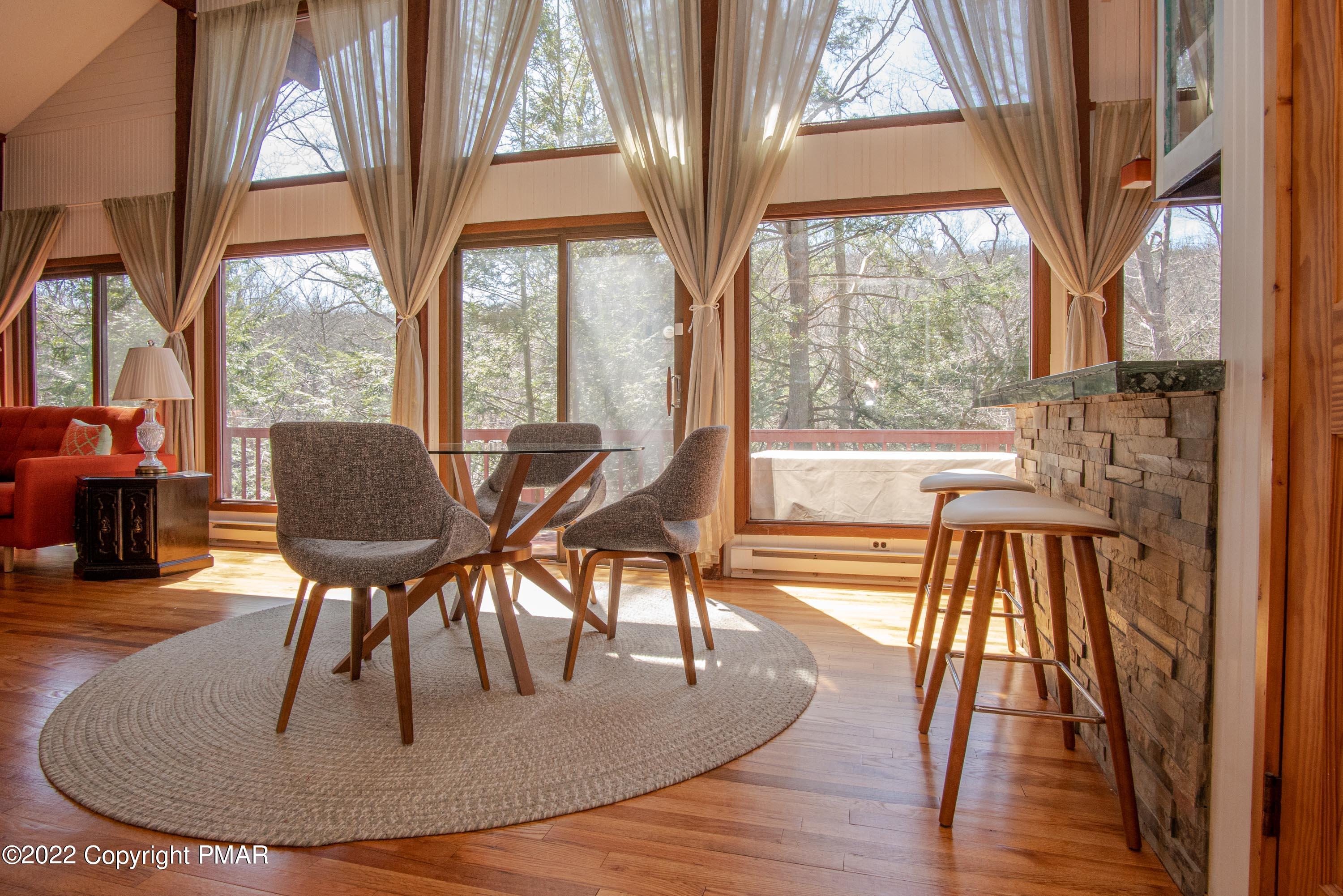 6374 Decker Road Bushkill, PA 18324 - Photo 7 of 60 a view of a dining room with furniture a chandelier and wooden floor