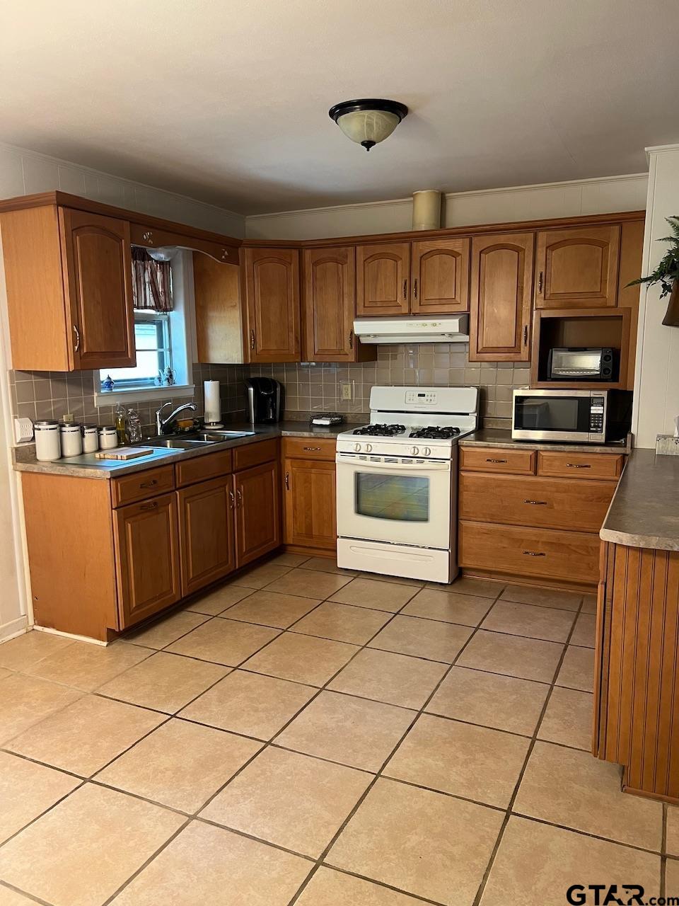 320 Bowers Street Lindale, TX 75771 - Photo 16 of 31 a kitchen with stainless steel appliances granite countertop a stove sink and cabinets