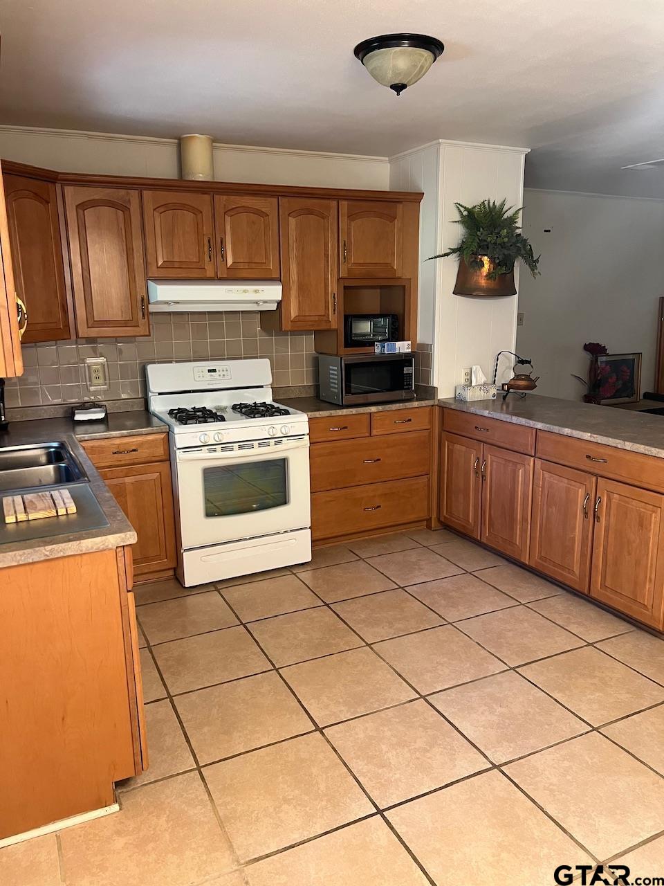 320 Bowers Street Lindale, TX 75771 - Photo 20 of 31 a kitchen with stainless steel appliances granite countertop a stove a sink dishwasher and a refrigerator
