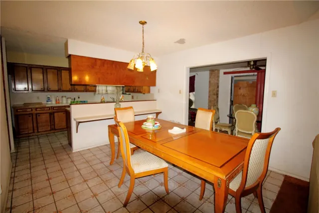 a dining hall with stainless steel appliances a table and chairs