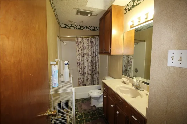 a bathroom with a double vanity sink toilet and shower
