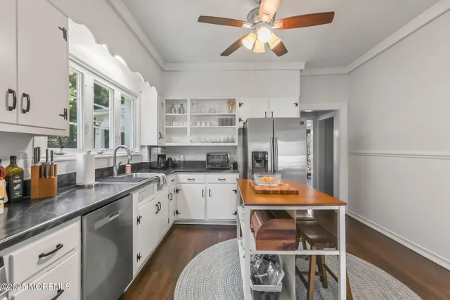 a kitchen with stainless steel appliances granite countertop a stove and white cabinets