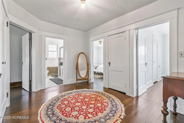 a view of a hallway with wooden floor and furniture