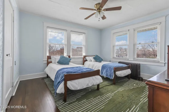 a bedroom with two beds and windows