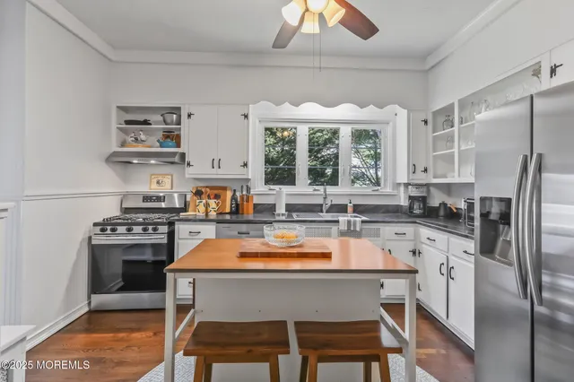 a kitchen with stainless steel appliances granite countertop a stove refrigerator and a more cabinets