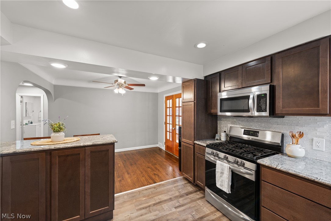21779 Eaton Road Cleveland, OH 44126 - Photo 11 of 46 Kitchen with light hardwood / wood-style flooring, stainless steel appliances, light stone counters, backsplash, and ceiling fan