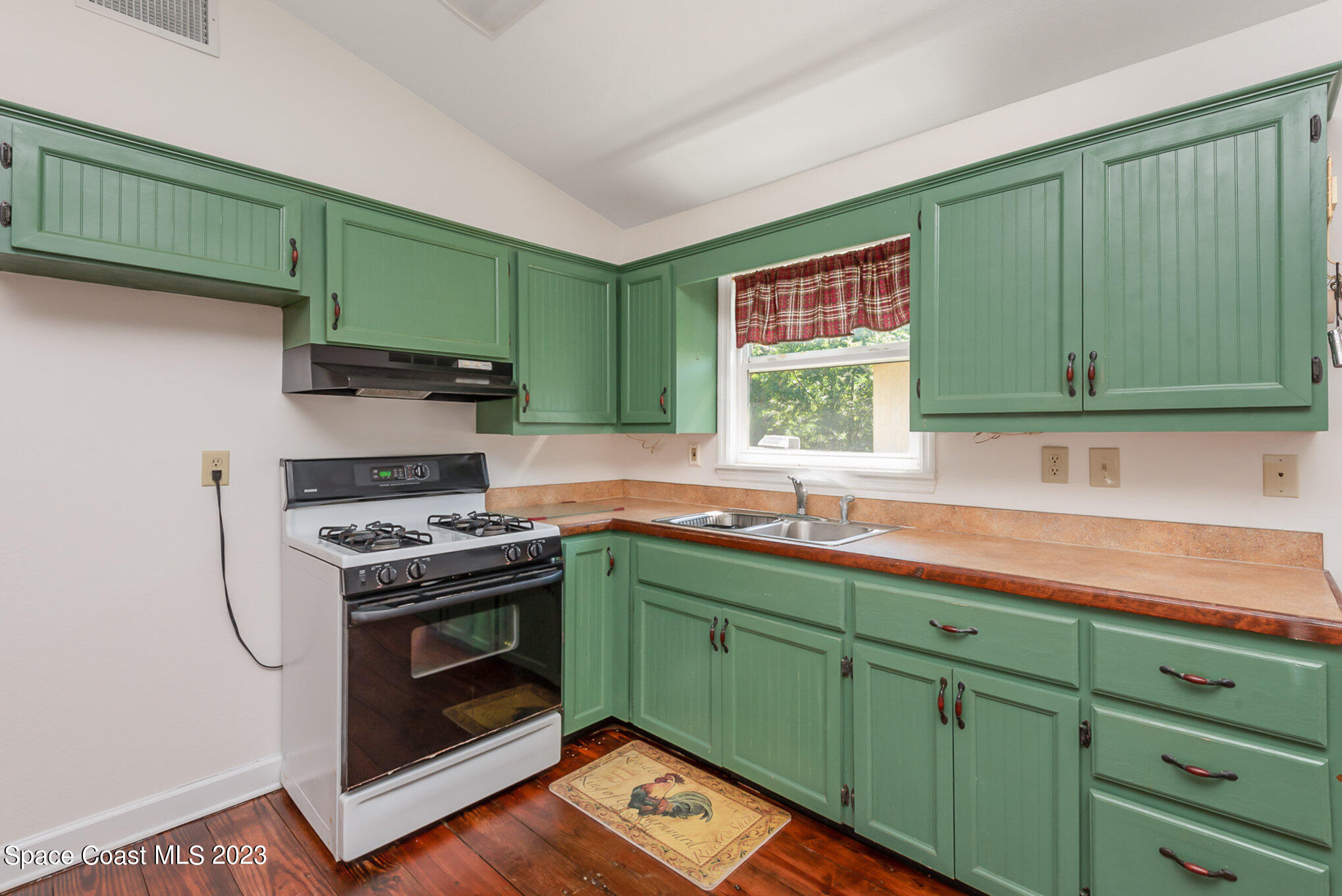 8219 Baxter Point Road Mims, FL 32754 - Photo 15 of 24 a kitchen with stainless steel appliances wooden cabinets and a stove top oven