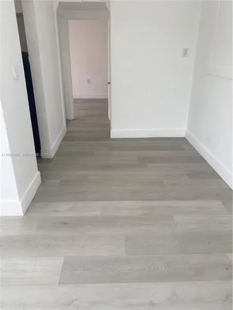 an empty room with wooden floor and staircase