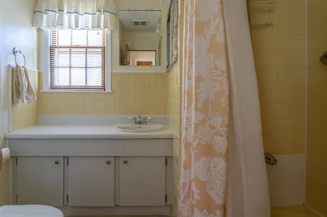 a bathroom with a granite countertop sink a mirror and a shower