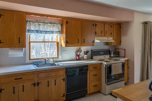 a kitchen with stainless steel appliances granite countertop a sink stove and cabinets