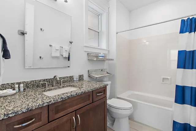 a bathroom with a granite countertop sink toilet and shower