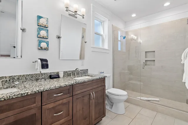 a bathroom with a granite countertop sink a toilet and a mirror