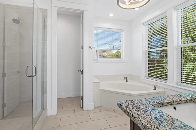 a bathroom with a tub a sink and a window