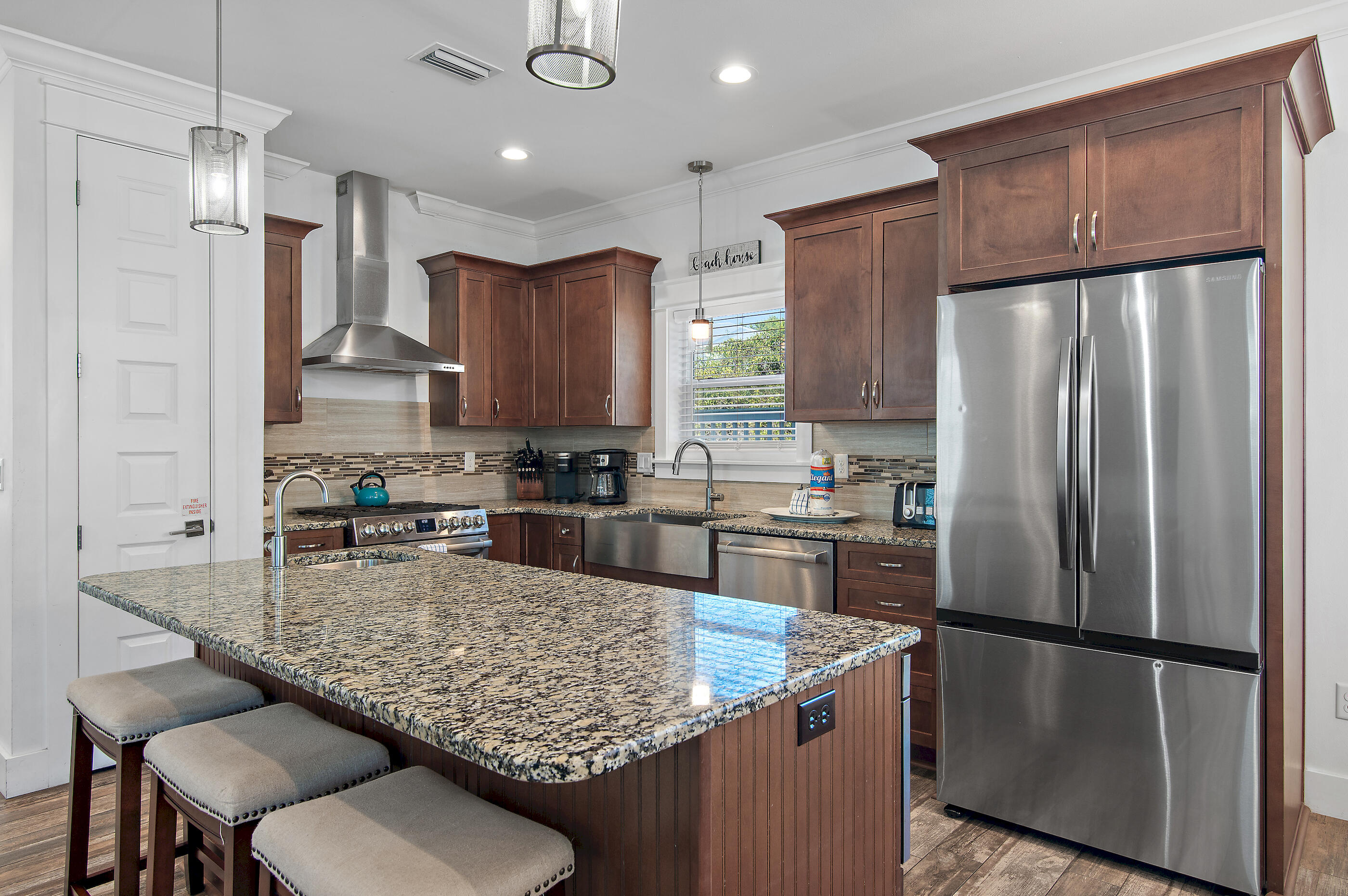 33 Sugar Sand Lane Santa Rosa Beach, FL 32459 - Photo 6 of 35 a kitchen with stainless steel appliances granite countertop a refrigerator a stove a sink a microwave and wooden cabinets