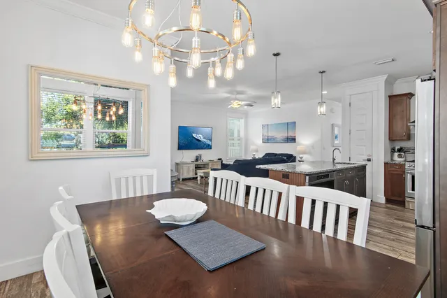 a view of a dining room with furniture a chandelier and wooden floor