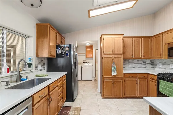 a kitchen with a sink refrigerator and cabinets