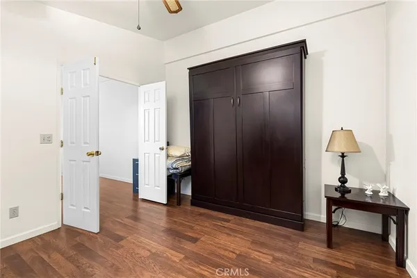 a view of a livingroom with wooden floor and a bathroom