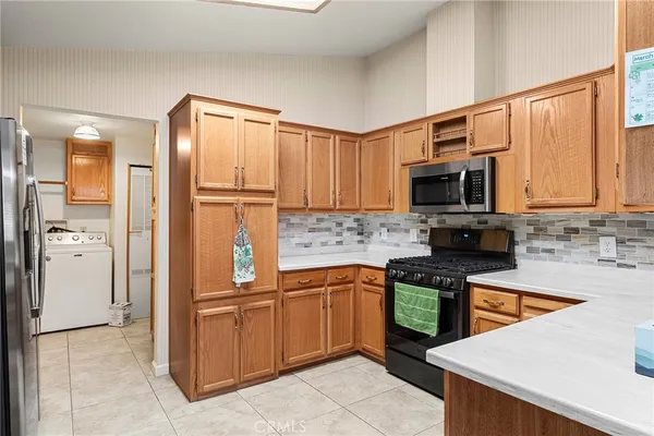 a kitchen with a refrigerator a microwave a sink and cabinets
