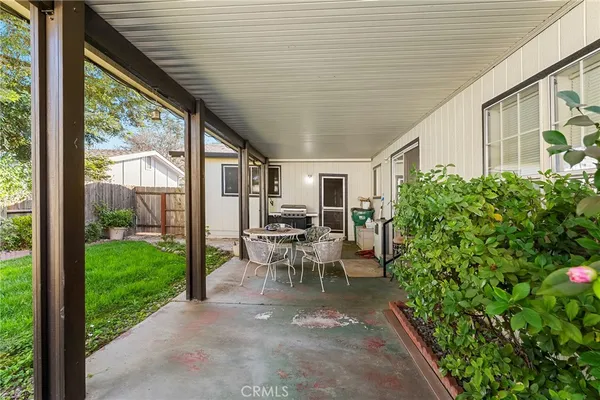 a view of a patio with table and chairs potted plants with floor to ceiling window