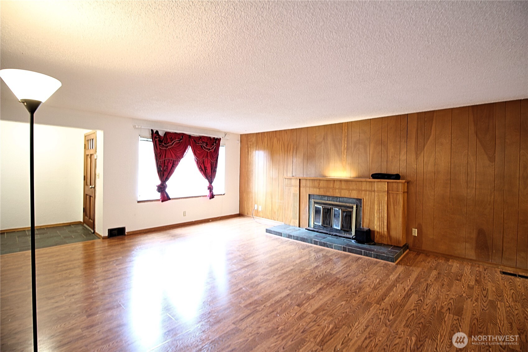 126 East 64th Street Tacoma, WA 98404 - Photo 3 of 36 an empty room with wooden floor fireplace and windows