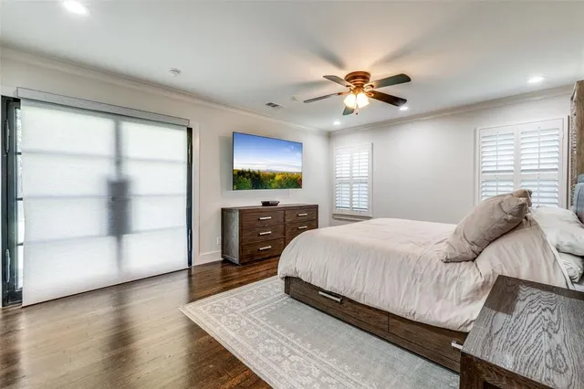 a bedroom with a bed and a flat tv screen on dresser