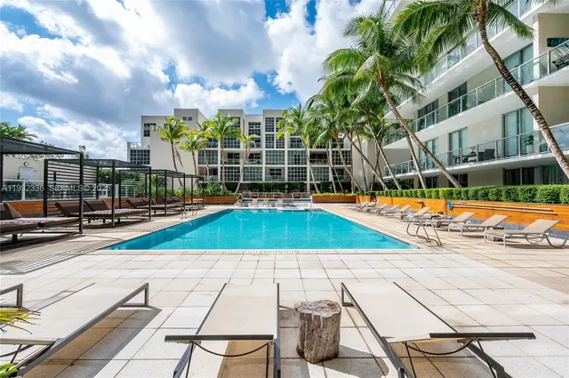 a view of swimming pool with seating space and garden view