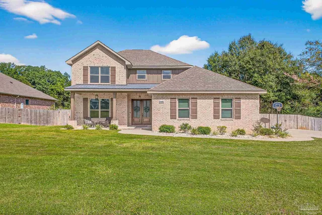 a front view of a house with a garden and yard