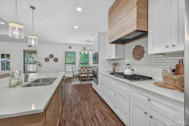 a large kitchen with stainless steel appliances lots of counter space and wooden floor