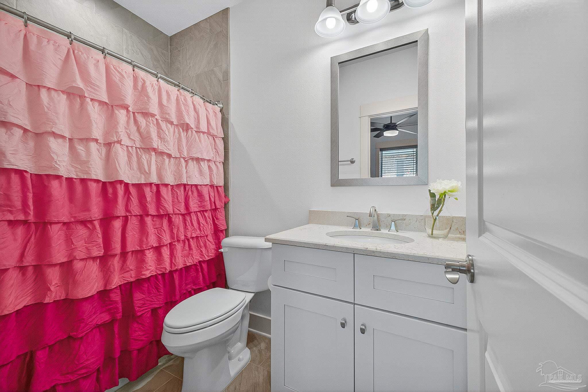 2480 Carthage Court Cantonment, FL 32533 - Photo 41 of 59 a bathroom with a sink a toilet and shower curtain