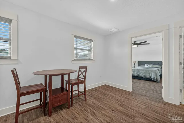 a bedroom with a bed a window and a wooden floor