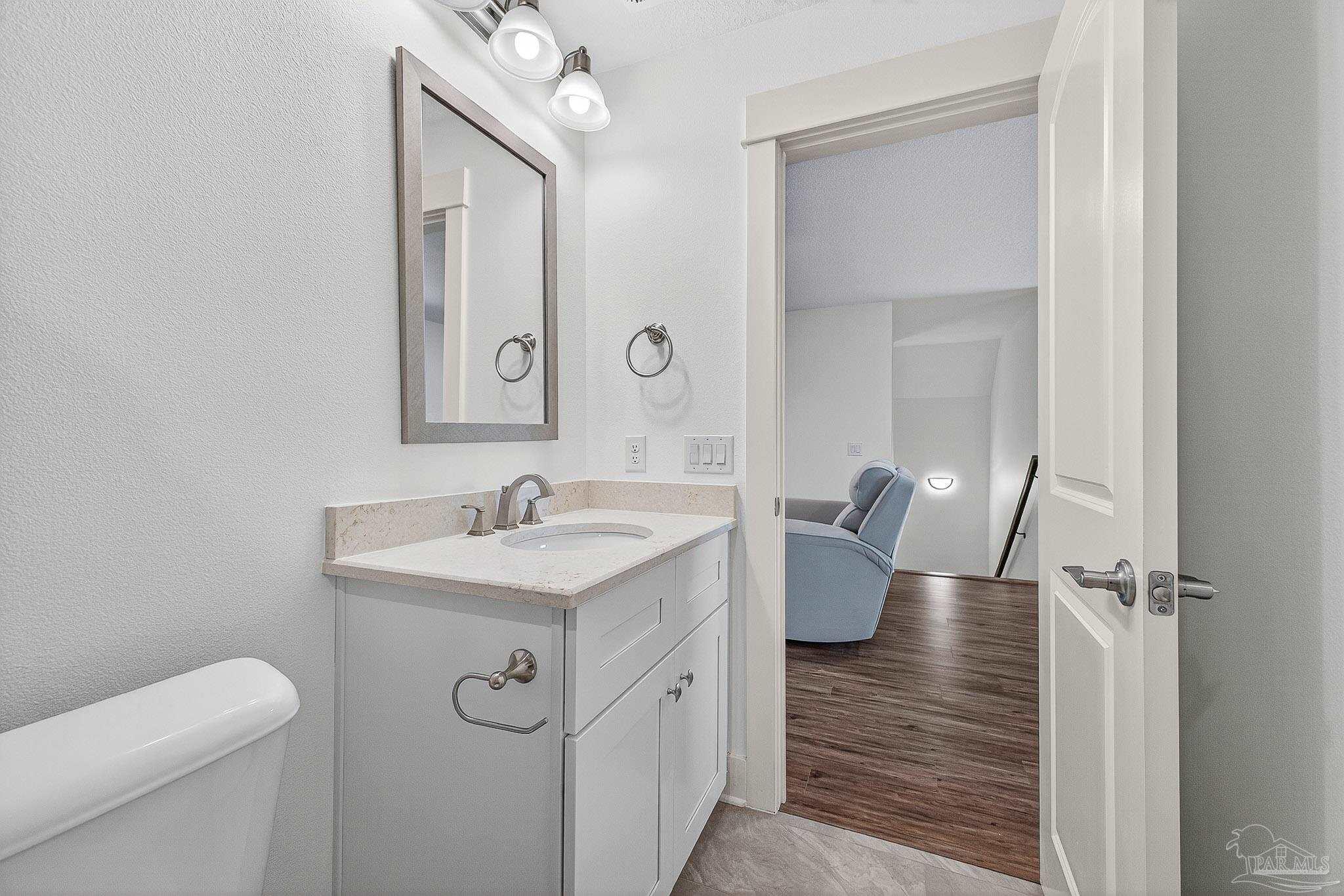 2480 Carthage Court Cantonment, FL 32533 - Photo 51 of 59 a bathroom with a granite countertop sink a toilet and a mirror