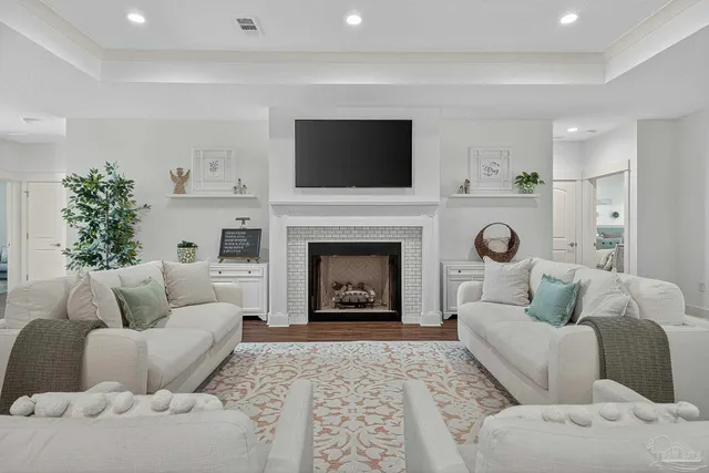 a living room with furniture a flat screen tv and a fireplace