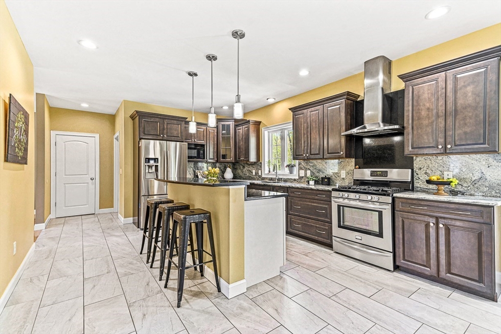 96 Clement Road Dracut, MA 01826 - Photo 4 of 41 a kitchen with stainless steel appliances granite countertop a refrigerator and a stove top oven