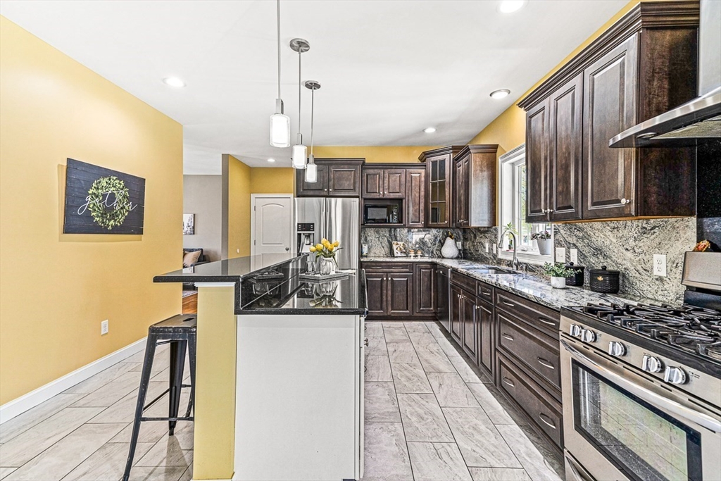 96 Clement Road Dracut, MA 01826 - Photo 6 of 41 a kitchen with stainless steel appliances kitchen island granite countertop a stove and cabinets