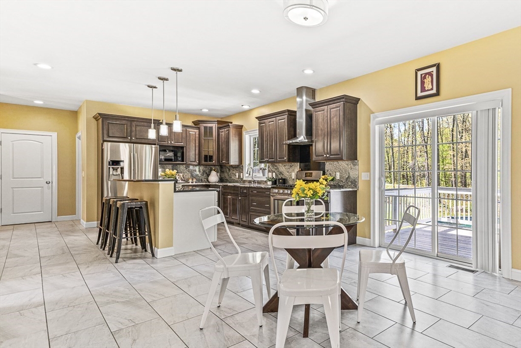 96 Clement Road Dracut, MA 01826 - Photo 9 of 41 a kitchen with stainless steel appliances kitchen island granite countertop a refrigerator and cabinets