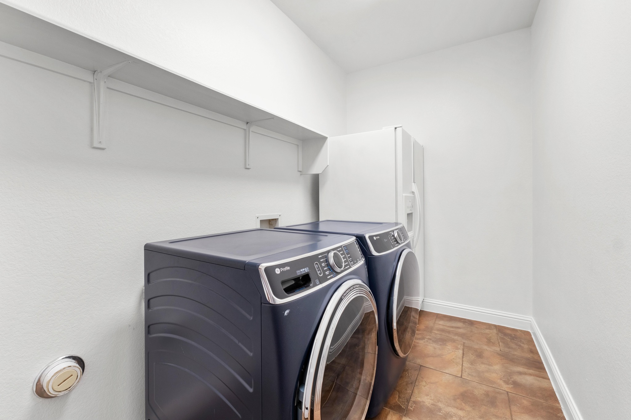 16200 Spillman Ranch Loop Austin, TX 78738 - Photo 34 of 36 Functional laundry space featuring modern appliances and practical wall-mounted shelving.