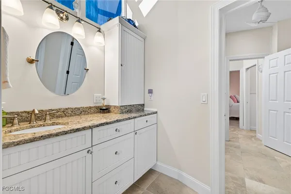a bathroom with a granite countertop double vanity sink and a mirror