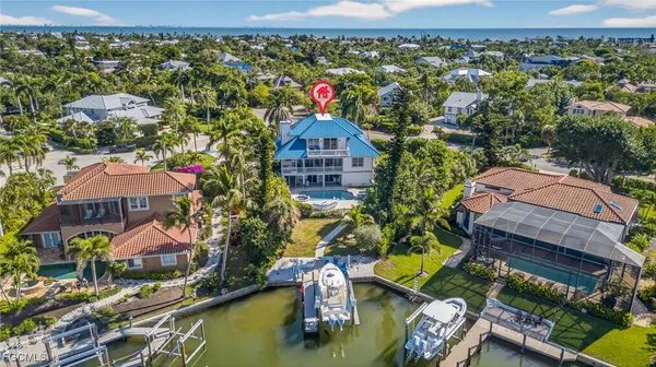 an aerial view of a house with a yard swimming pool and outdoor seating