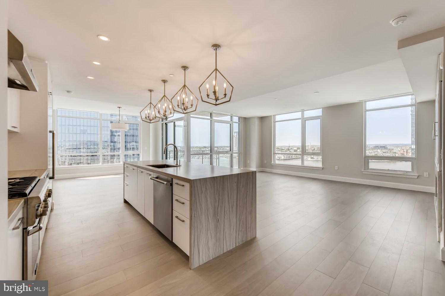 a open kitchen with stainless steel appliances granite countertop a stove oven and a large window with wooden floor