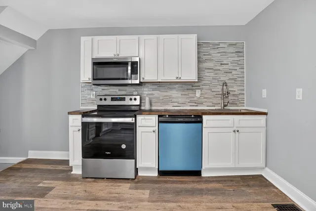 a kitchen with stainless steel appliances granite countertop a stove a microwave and a sink