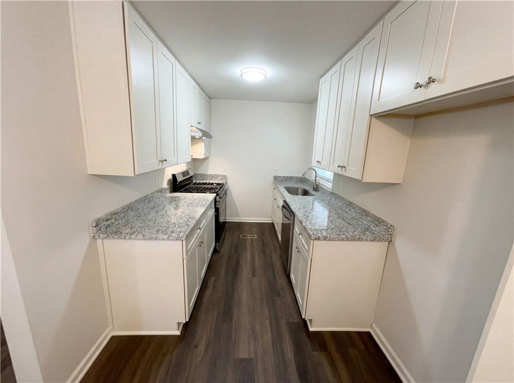 161 Grove Road Locust Grove, GA 30248 - Photo 2 of 18 a kitchen with granite countertop a sink stove and cabinets
