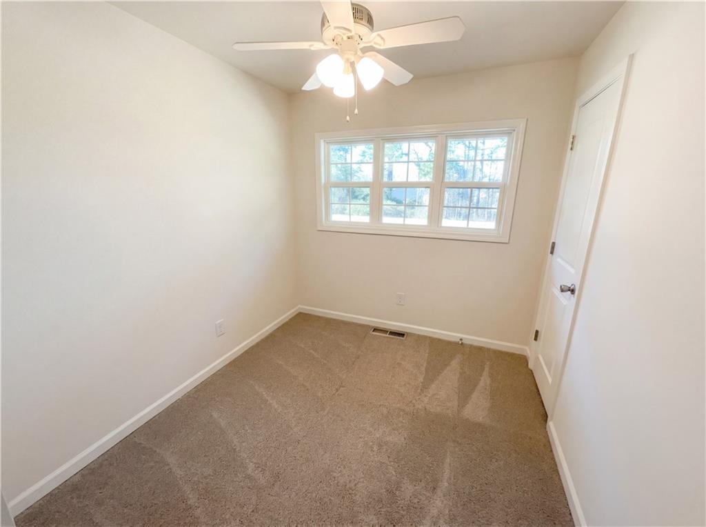 161 Grove Road Locust Grove, GA 30248 - Photo 6 of 18 an empty room with a window and a fan