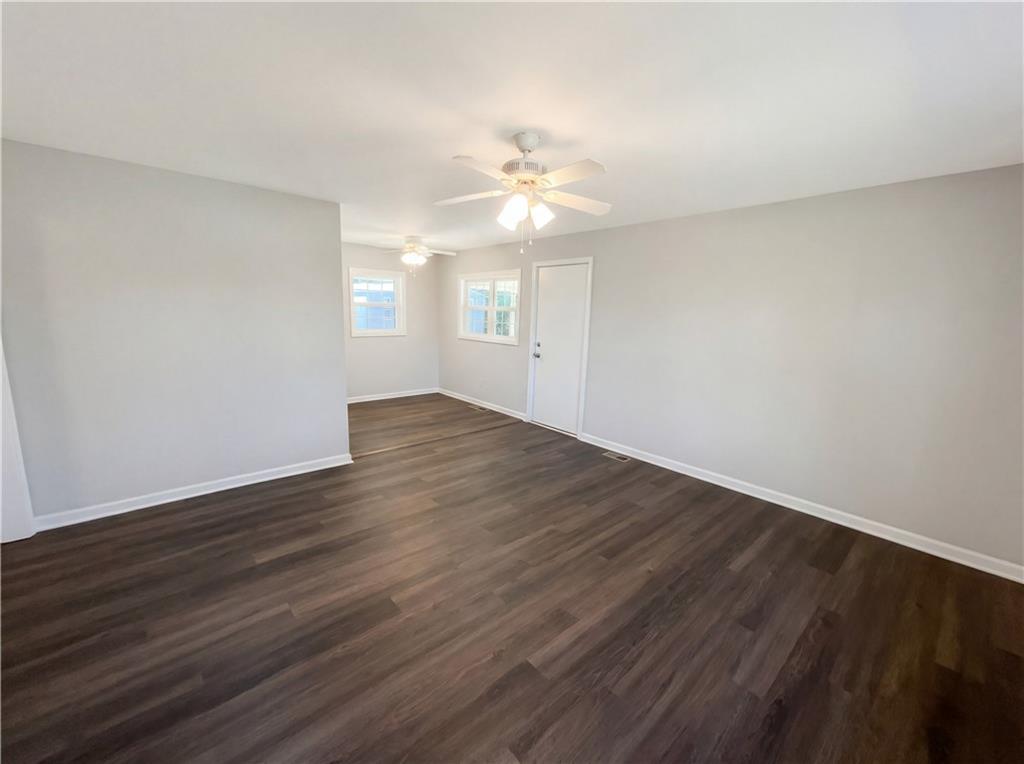 161 Grove Road Locust Grove, GA 30248 - Photo 7 of 18 a view of an empty room with wooden floor and a ceiling fan